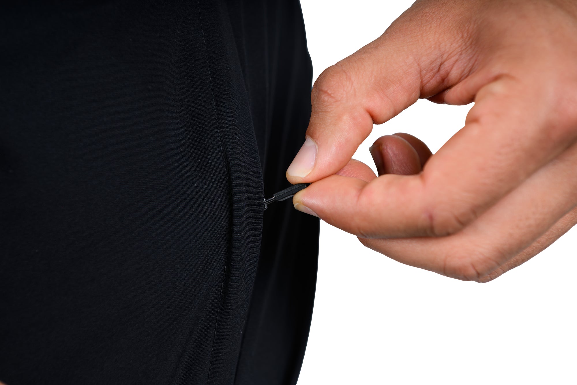 Hand using a needle and thread on a black fabric background