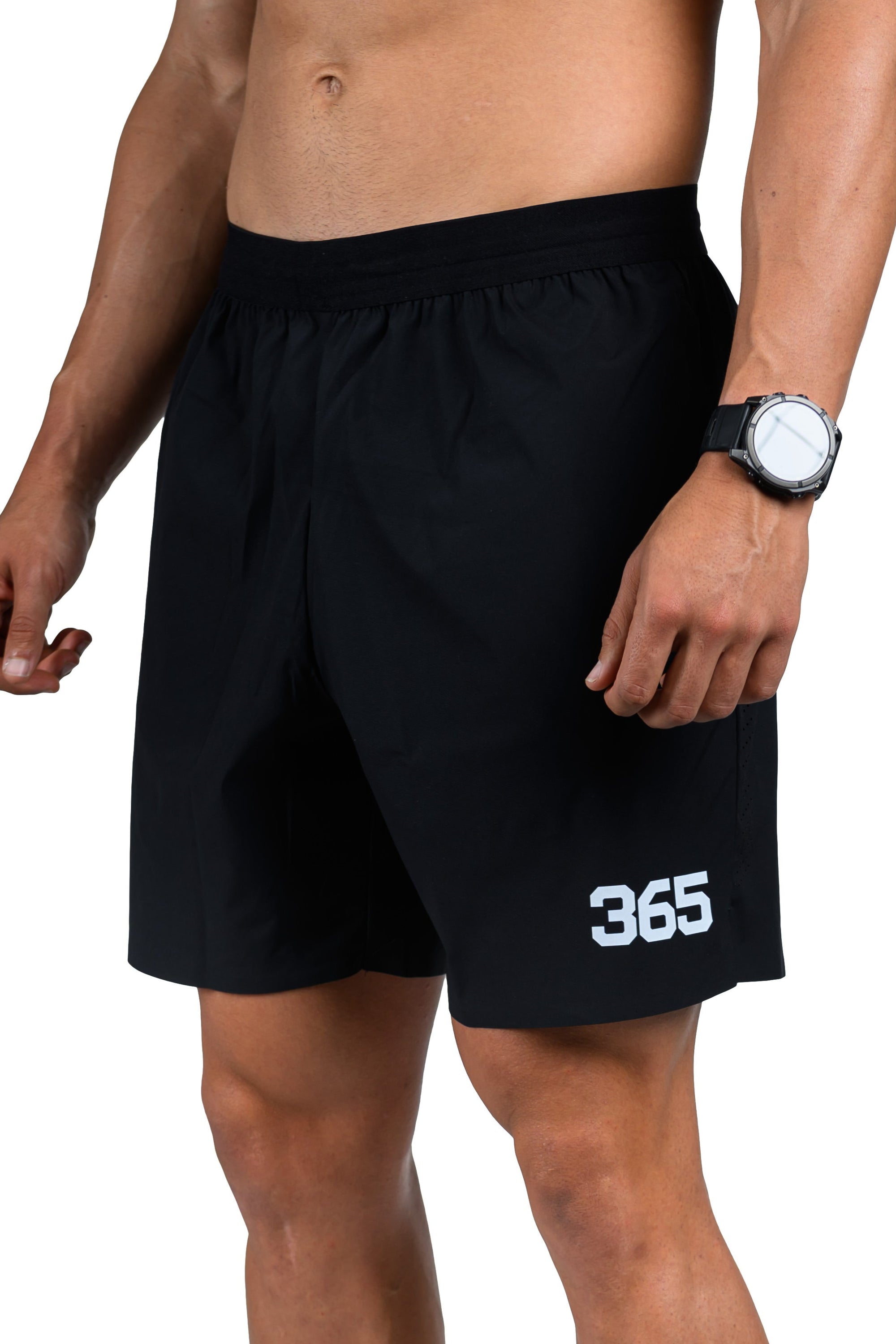 Person wearing black athletic shorts with '365' logo and white sneakers on a white background