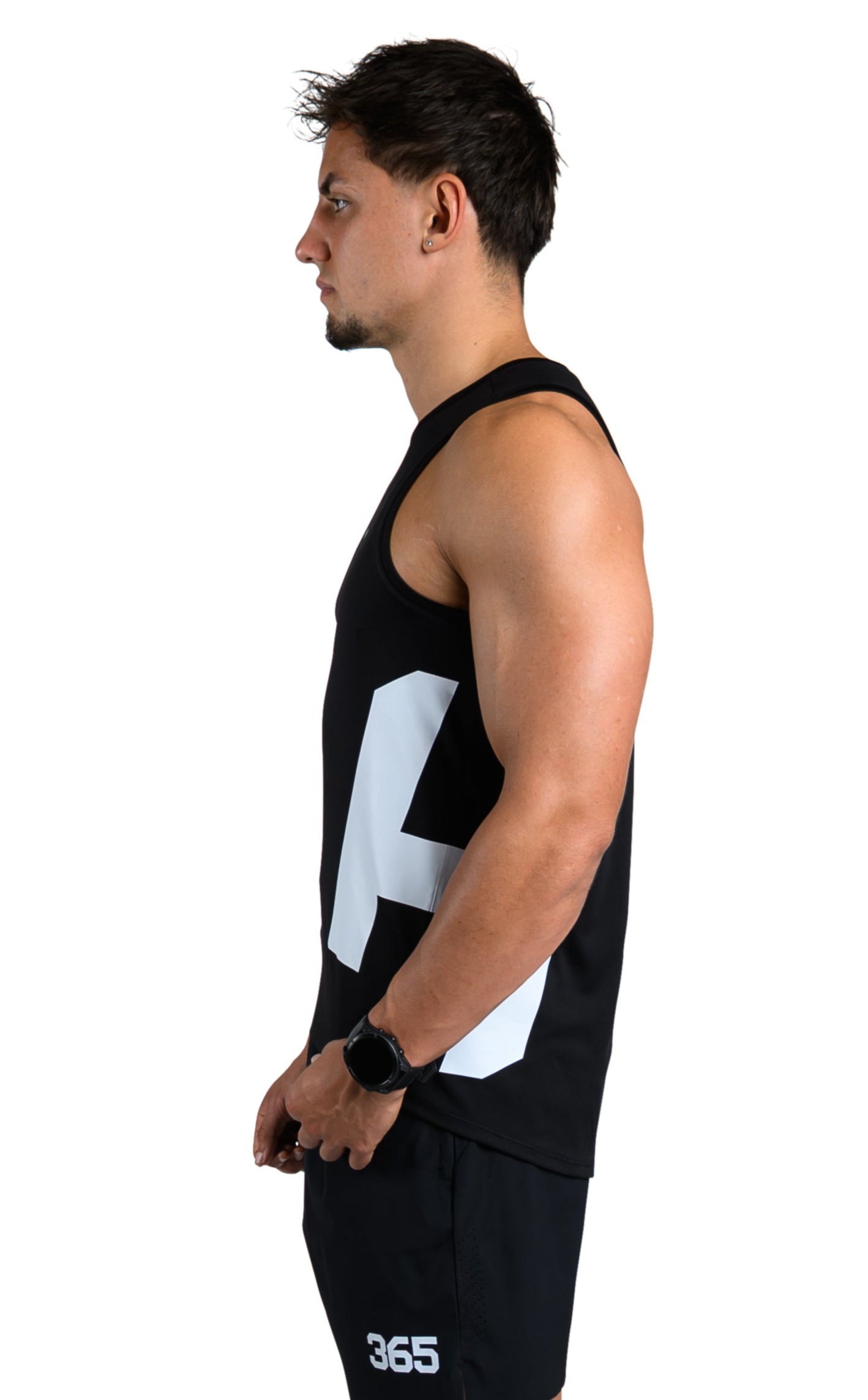 Person wearing a black tank top with a white logo and black shorts on a white background