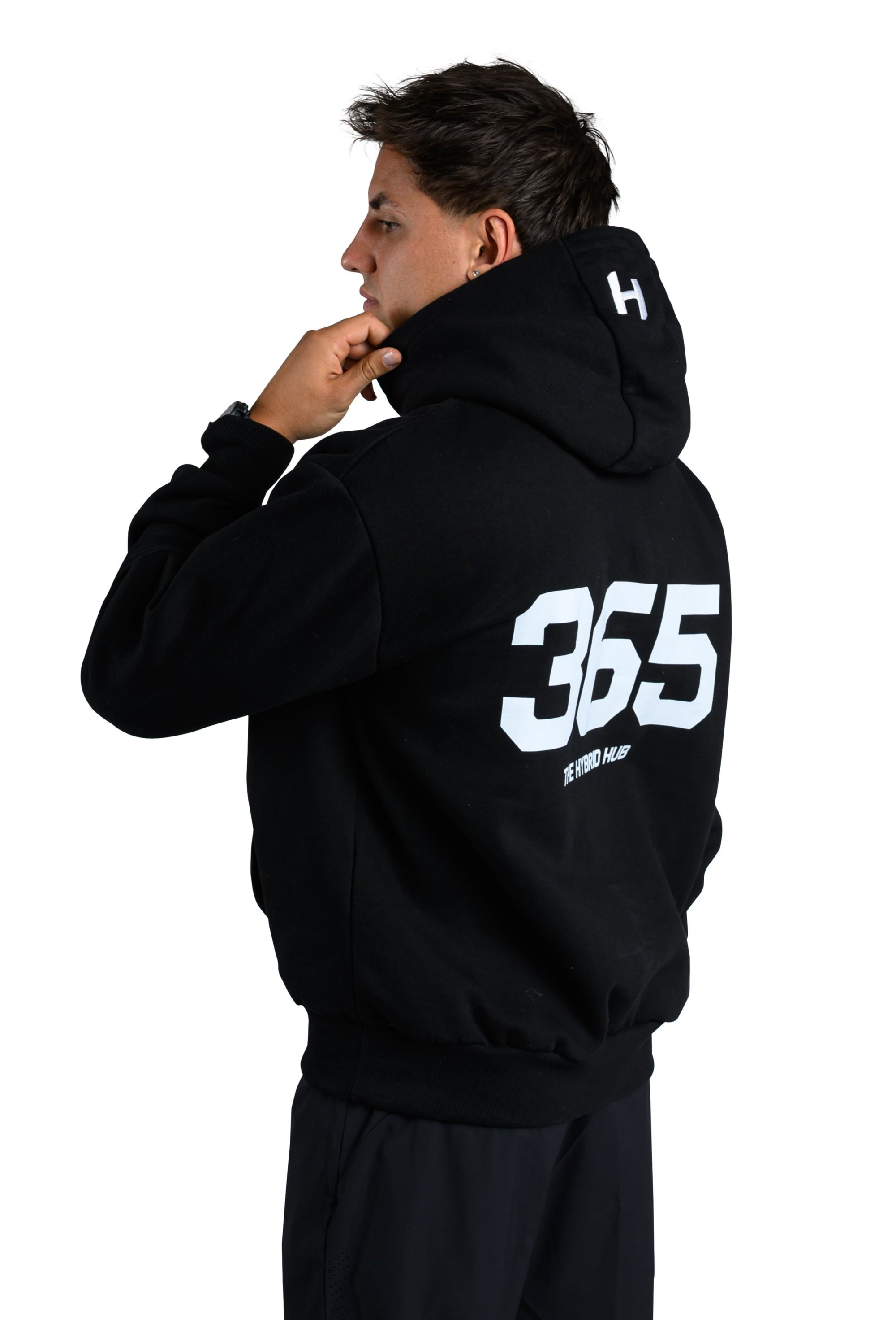 Person wearing a black hoodie with '365' printed on the back, standing against a white background.