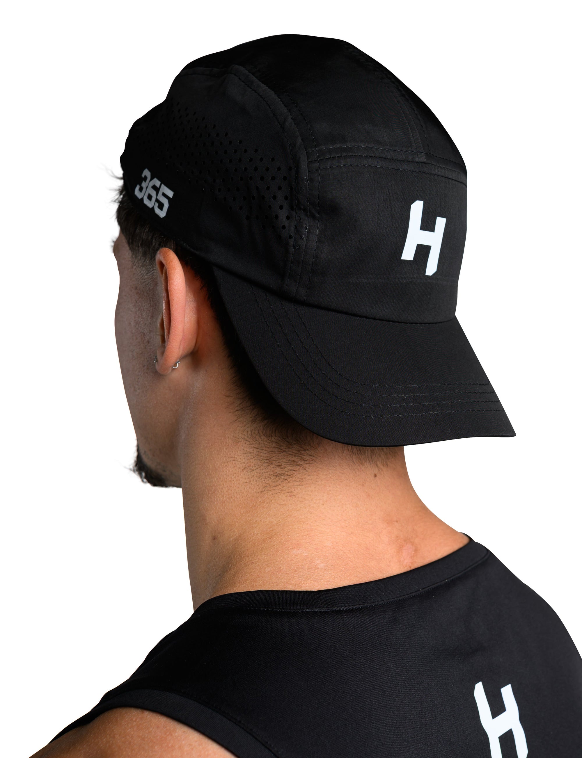 Person wearing a black cap and black shirt with a logo on a white background