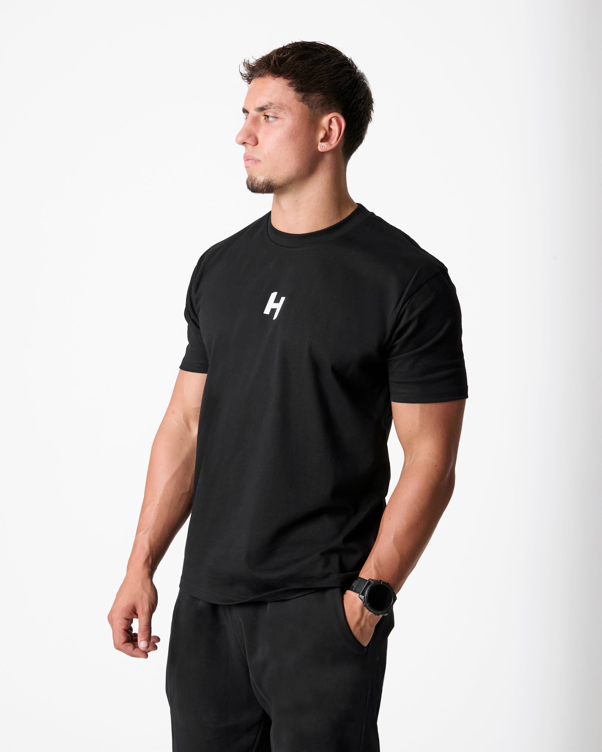 Man wearing a black t-shirt with a logo on a white background