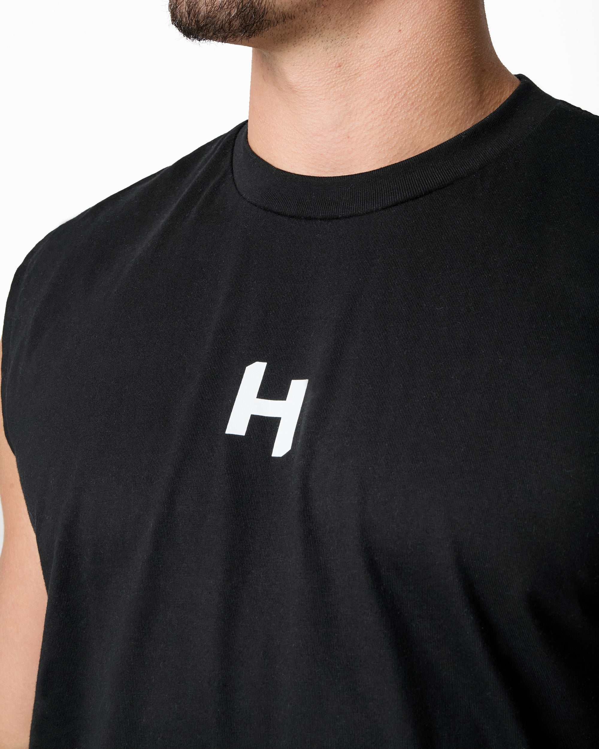Black sleeveless shirt with a white logo on a plain background