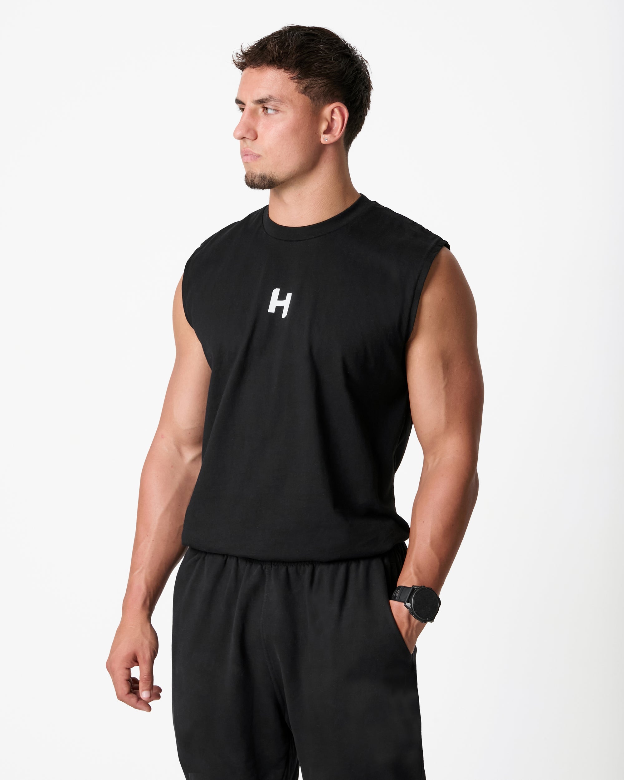 Man wearing a black sleeveless shirt with a logo on a white background