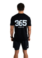 Person wearing a black t-shirt with '365' printed on the back, standing against a white background.