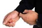 Person adjusting a black sleeve on their arm against a white background
